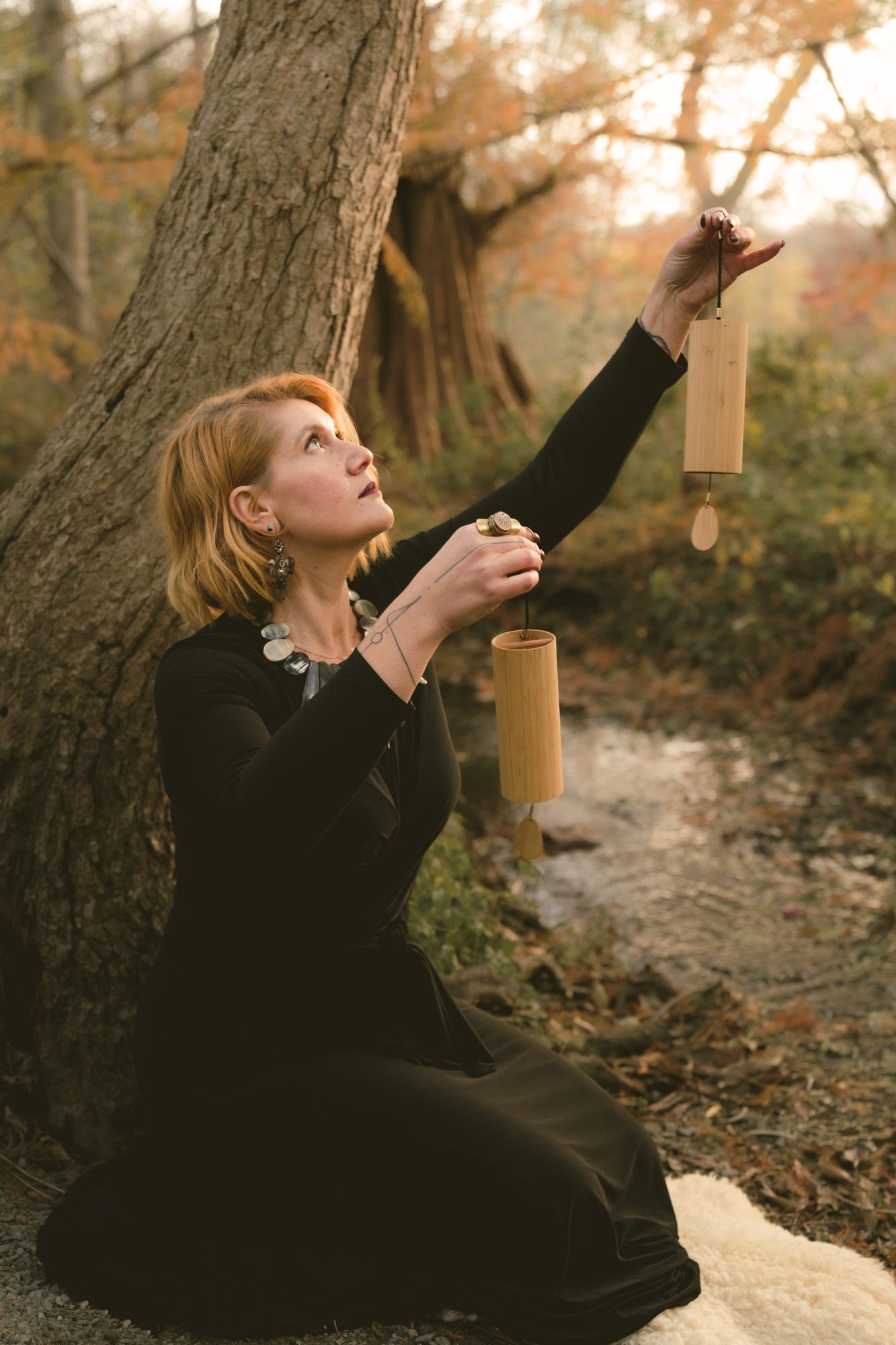 Lara holding koshi chimes, looking upward